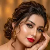 Elegant Indian bride in red lehenga with heavy gold jewelry and bridal makeup in palace setting