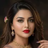 Elegant party makeup with bold red lips, soft glam eyes, and textured updo hairstyle